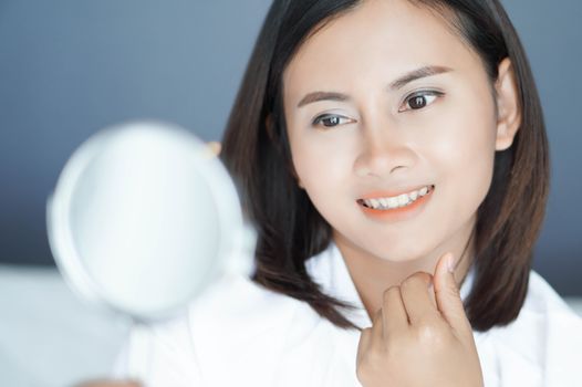 Close up face of woman looking the mirror with happy feeling, health care and beauty concept