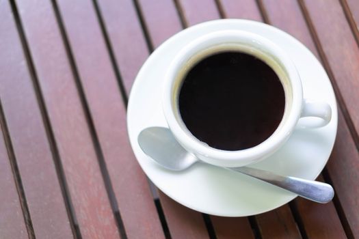 Closeup glass of hot americano coffee on wood table, selective focus, vintage tone