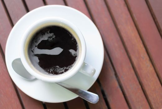 Closeup glass of hot americano coffee on wood table, selective focus, vintage tone