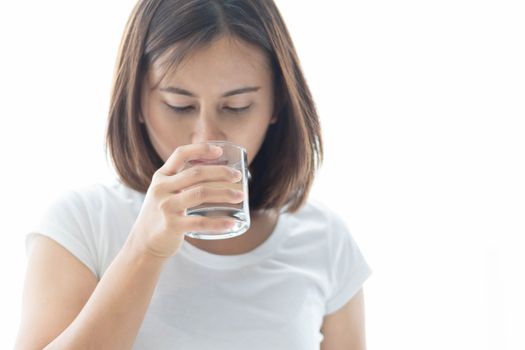 Close up woman drinking pure water from glass with light in the morning, Selective focus
