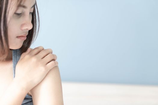 Closeup woman hand holding shoulder with pain on white background