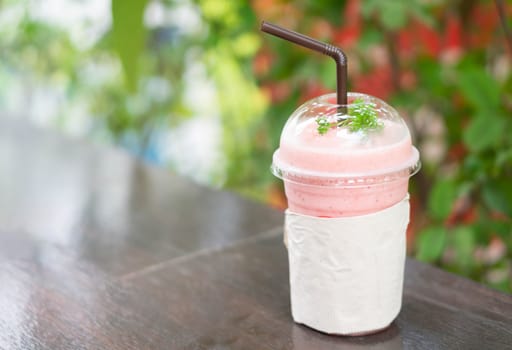 Closeup  strawberry smoothie with green nature background, selective focus