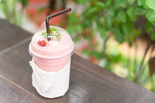 Closeup  strawberry smoothie with green nature background, selective focus