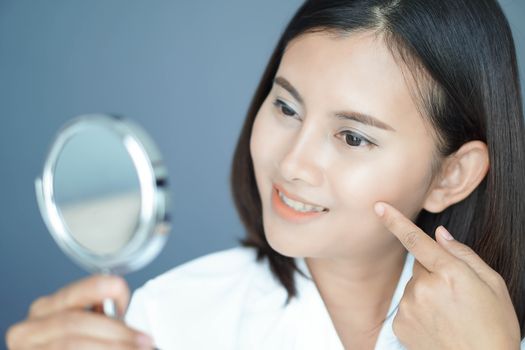 Close up face of woman looking the mirror with happy feeling, health care and beauty concept