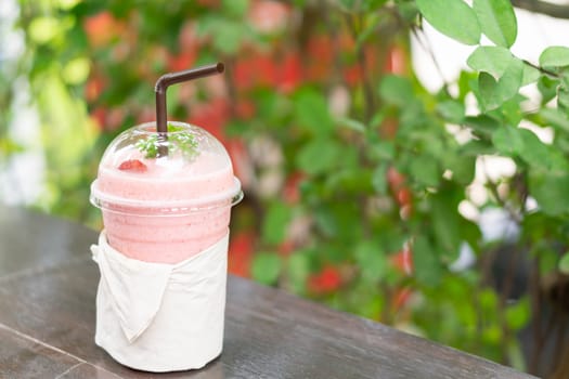 Closeup  strawberry smoothie with green nature background, selective focus