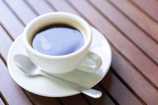 Closeup glass of hot americano coffee on wood table, selective focus, vintage tone