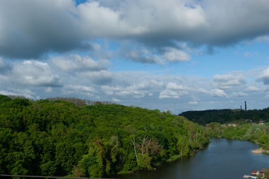 River, forest and blue sky with clouds.