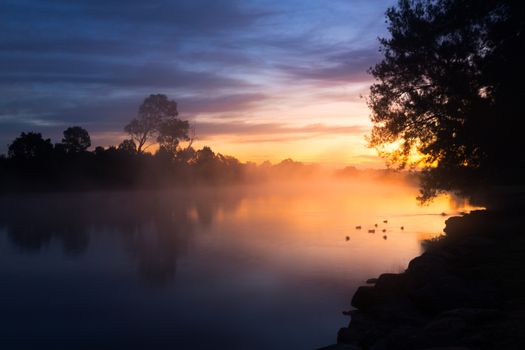 Pretty dawn skies colour the misty fog over the billabong on a chilly morning