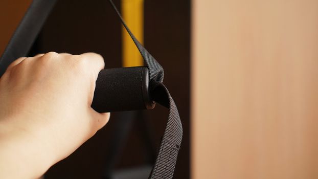 Close up on hands doing suspension training - sport at home