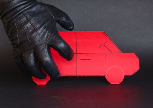 A thief's hand approaches a car to steal it