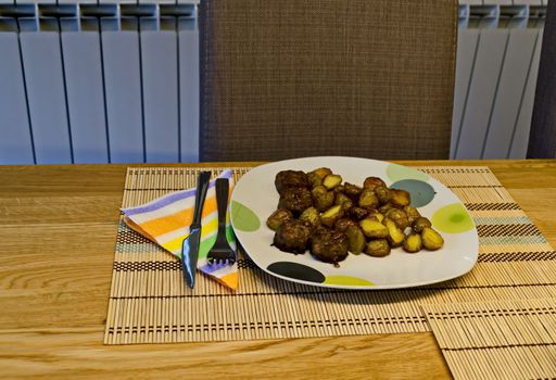 Served appetizing dinner of fried potatoes and green salad on a table, Sofia, Bulgaria