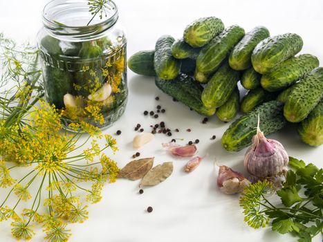 Cucumbers on the table are washed and ready for canning in a jar with spices, garlic, pepper, bay leaves, garlic, dill, parsley. Harvesting vegetables for the winter in banks
