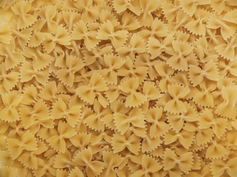 Macro curly in the form of bows are laid out on the table in the form of a background very tightly beautiful yellow appetizing ingredients for cooking
