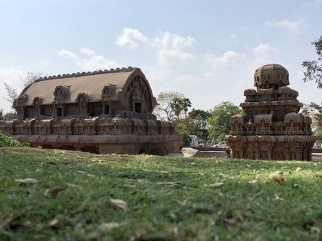 Pancha Rathas is an example of monolith Indian rock-cut architecture. Resembling a chariot ratha, it is carved out of a single, long stone of pink granite. This is one of the Group of Monuments at Mahabalipuram and also a UNESCO World Heritage Site. In this view monuments of Pancha Rathas are beautifully captures from the grass meadow area.