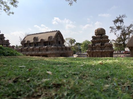 Pancha Rathas is an example of monolith Indian rock-cut architecture. Resembling a chariot ratha, it is carved out of a single, long stone of pink granite. This is one of the Group of Monuments at Mahabalipuram and also a UNESCO World Heritage Site. In this view monuments of Pancha Rathas are beautifully captures from the grass meadow area.