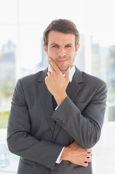 Portrait of a young businessman standing over blurred background outdoors