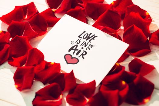 love is in the air against card surrounded by rose petals