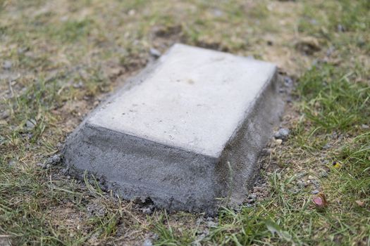 concrete block embeded on a ground surrounded by grass