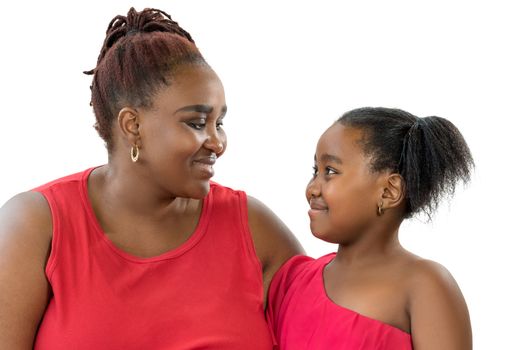 Close up portrait of African mother with little daughter looking at each other. Women dressed alike in red showing affection smiling at each other isolated on white background.
