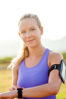 Close up portrait of attractive young woman wearing smart watch and smart watch armband. Young athlete in sport wear.