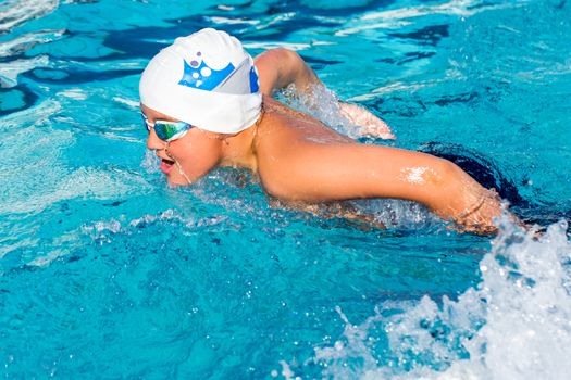 Close up of teenager swimming butterfly stoke.Side view of young student at swim practice.