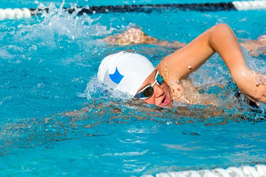 Close up action shot of teen freestyler competing in swim gala.