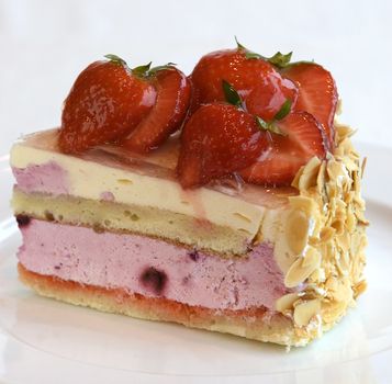 Fresh fruit cake with strawberries and sliced nuts. Close up view.