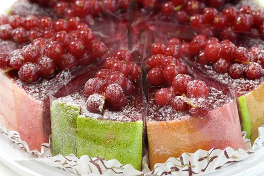 Fresh fruit cake with red currant sliced in pieces. Close up view.
