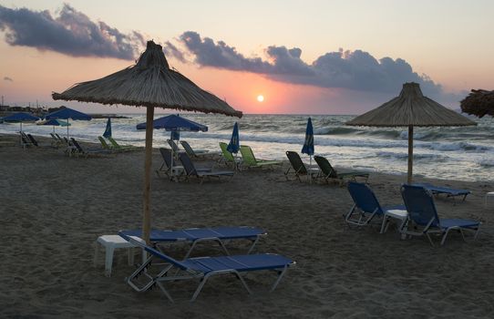 View of empty deck chairs on the beach at sunset. Tourism crisis.