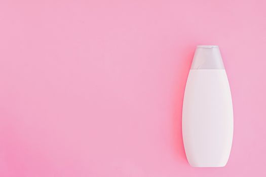 Blank label shampoo bottle or shower gel on pink background, beauty product and body care cosmetics, flatlay