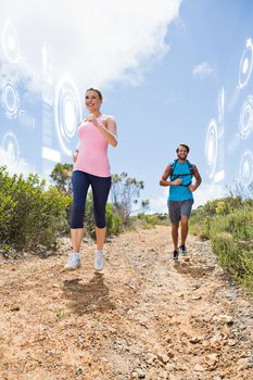 Fit attractive couple jogging down mountain trail against fitness interface