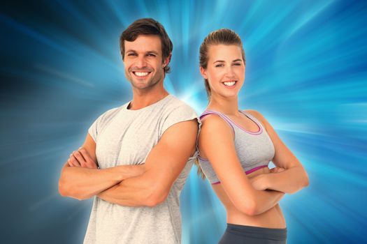 Portrait of a sporty young couple with arms crossed against abstract background