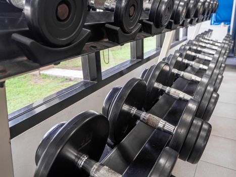 dumbbell set. Close up many metal dumbbells on rack in sport fitness center