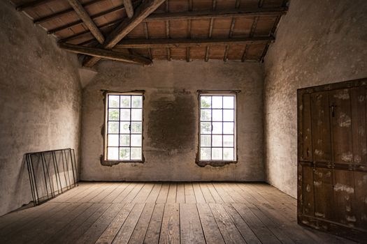 Empty room in an abandoned house with window and wooden floor