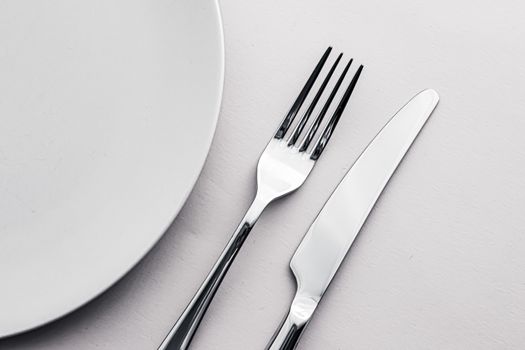 Empty plate and cutlery as mockup set on white background, top tableware for chef table decor and menu branding design