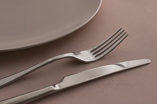 Empty plate and cutlery as mockup set on brown background, top tableware for chef table decor and menu branding design