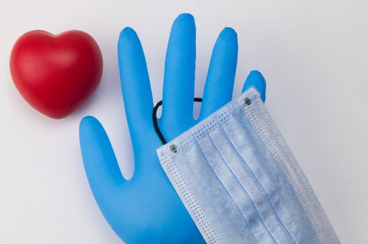 Medical mask and gloves on a white background. Toy heart. Coronavirus Protection Concept