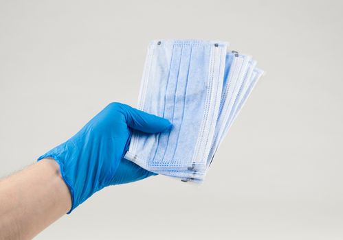 Hand holding a medical protective mask on a white background. Coronavirus Protection Concept