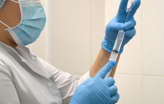 Doctor prepares a syringe with an injection, close-up