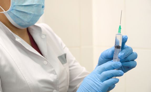 Doctor prepares a syringe with an injection, close-up