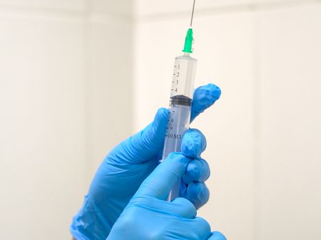 Doctor prepares a syringe with an injection, close-up