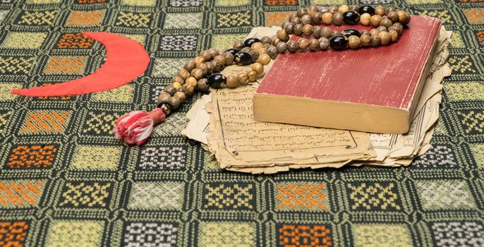 Muslim prayer beads with Quran and with sheets with ancient Arabic scripts. Islamic and Muslim concepts