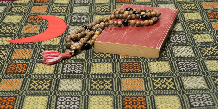 Muslim prayer beads and Koran on the prayer Mat. Islamic and Muslim concepts