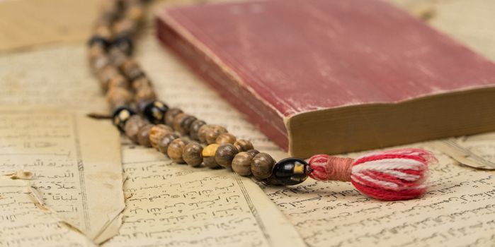 Muslim prayer beads with Quran and with sheets with ancient Arabic scripts. Islamic and Muslim concepts