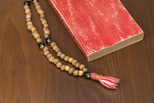 Muslim prayer beads and Quran isolated on a wooden background. Islamic and Muslim concepts