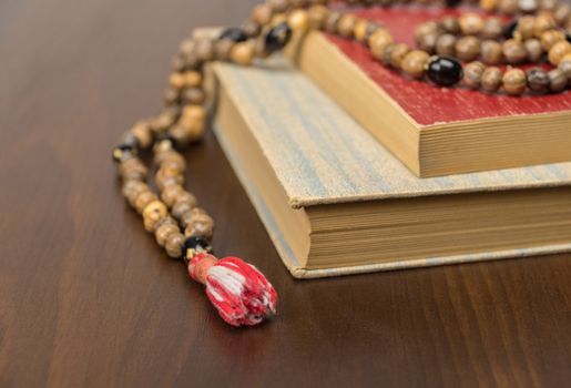 Muslim prayer beads and Quran isolated on a wooden background. Islamic and Muslim concepts