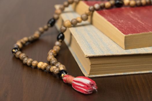 Muslim prayer beads and Koran isolated on a wooden background. Islamic and Muslim concepts