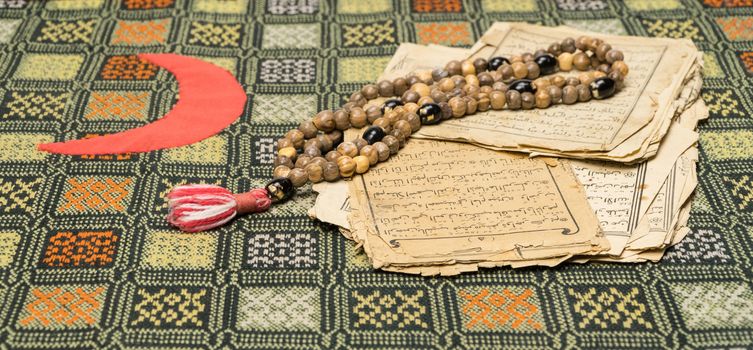 Muslim prayer beads with ancient pages from the Koran. Islamic and Muslim concepts. Ancient old sheets of paper from the Arabic book