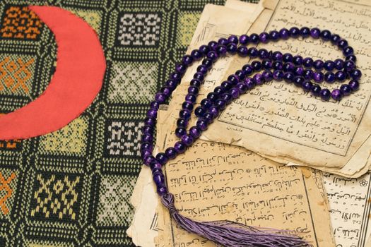 Muslim prayer beads with ancient pages from the Koran. Islamic and Muslim concepts. Ancient old sheets of paper from the Arabic book