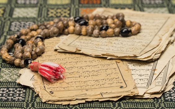 Muslim prayer beads with ancient pages from the Koran. Islamic and Muslim concepts. Ancient old sheets of paper from the Arabic book